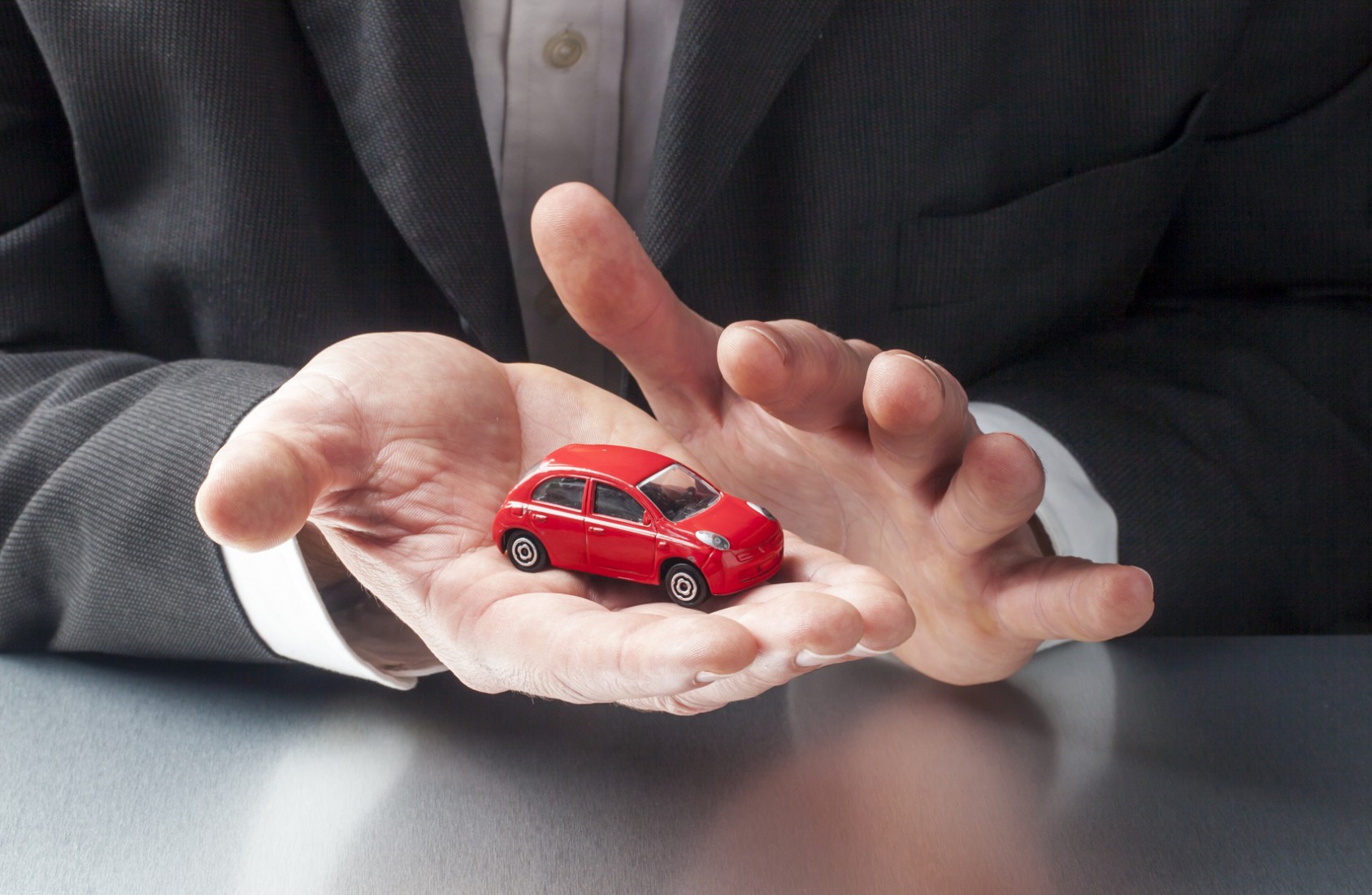 businessman hands displaying car at the office